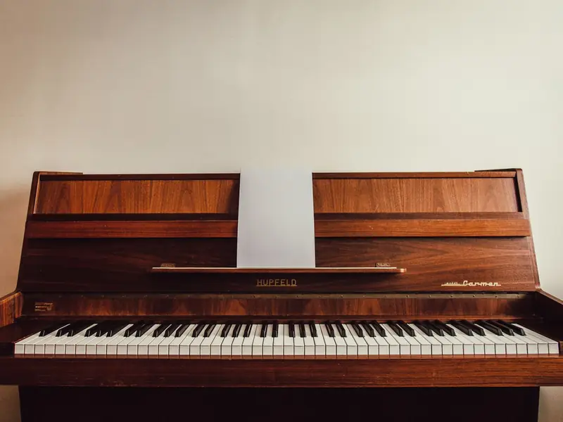 Klaviertransport und Spezialtransport in Erding: klassisches Holzklavier vor heller Wand